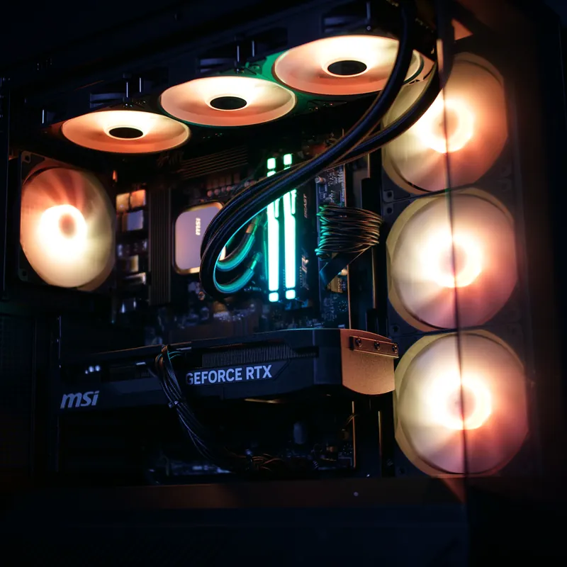 MSI MAG PANO 130R PZ in Schwarz, Innenraum schräg von vorn, warmweiß und orange beleuchtet, Grafikkarte und Lüftersäule