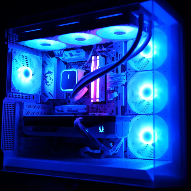 MSI MAG PANO 130R PZ in Weiß, ganzes Gehäuse leicht von oben, blau beleuchtet, Lüftersäule rechts hinter Glas