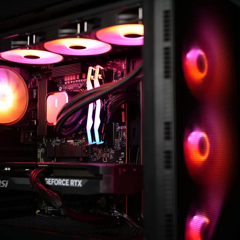 MSI MAG FORGE 320R Airflow in Schwarz, Innenraum pink und orange beleuchtet, rechts die Frontlüfter hinter dem Mesh