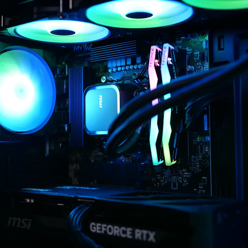 MSI MAG FORGE 320R Airflow in Schwarz, Detail: Pumpe der Wasserkühlung, Arbeitsspeicher und Lüfter, cyan und grün beleuchtet