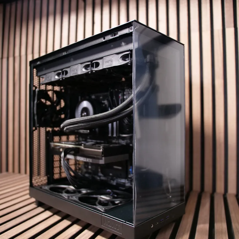 NZXT H6 Flow in Schwarz, unbeleuchteter Beispielaufbau von vorn links vor Holzlamellen